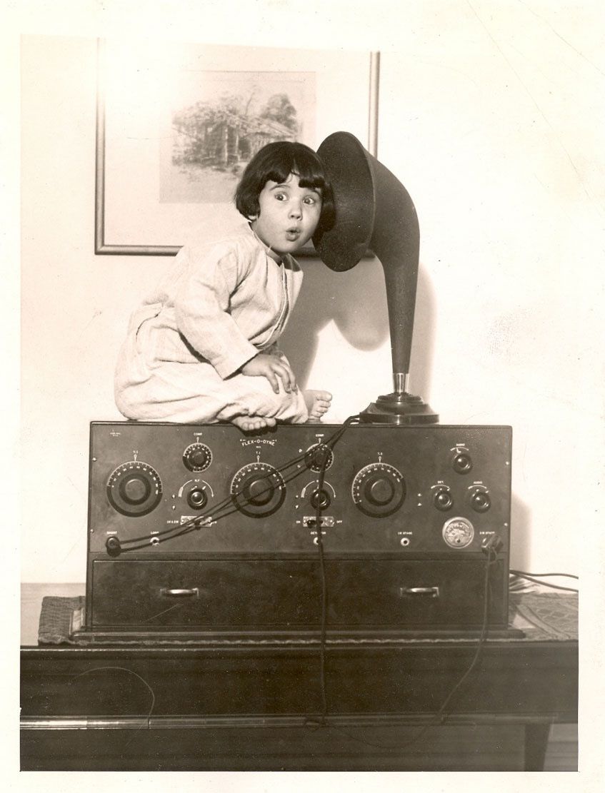 Little girl listening to vintage radio