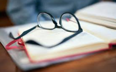 Glasses sitting on book in out of focus picture.